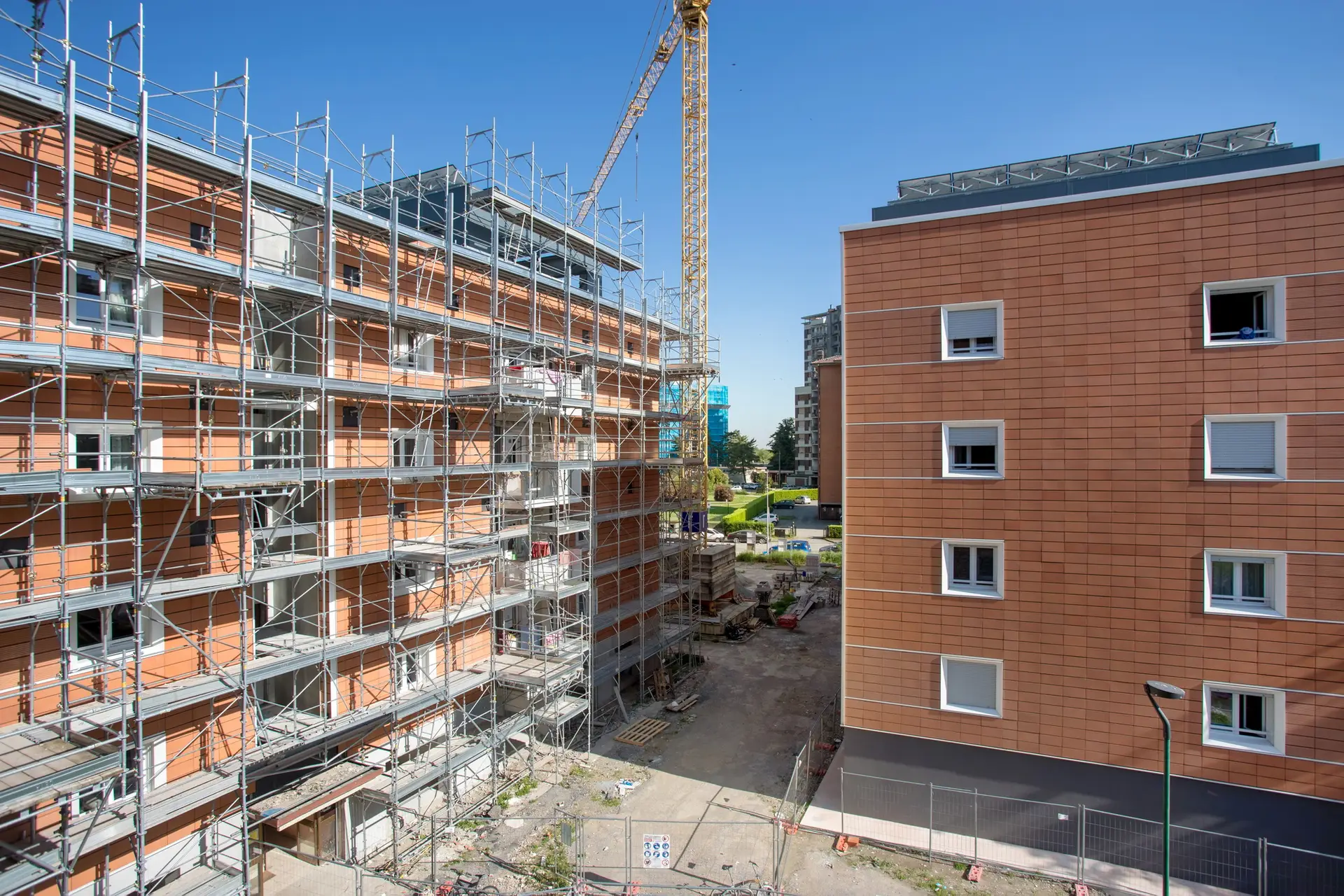 Construction site with scaffolding, new building under renovation, crane in background, showcasing commercial construction management and tenant improvement services.