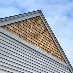 Cedar shake and white clapboard siding on accessory dwelling unit in Essex, MA, showcasing architectural details and roofing design.