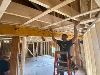 Framing crew installing ceiling joists in newly constructed accessory dwelling unit in Essex, MA.