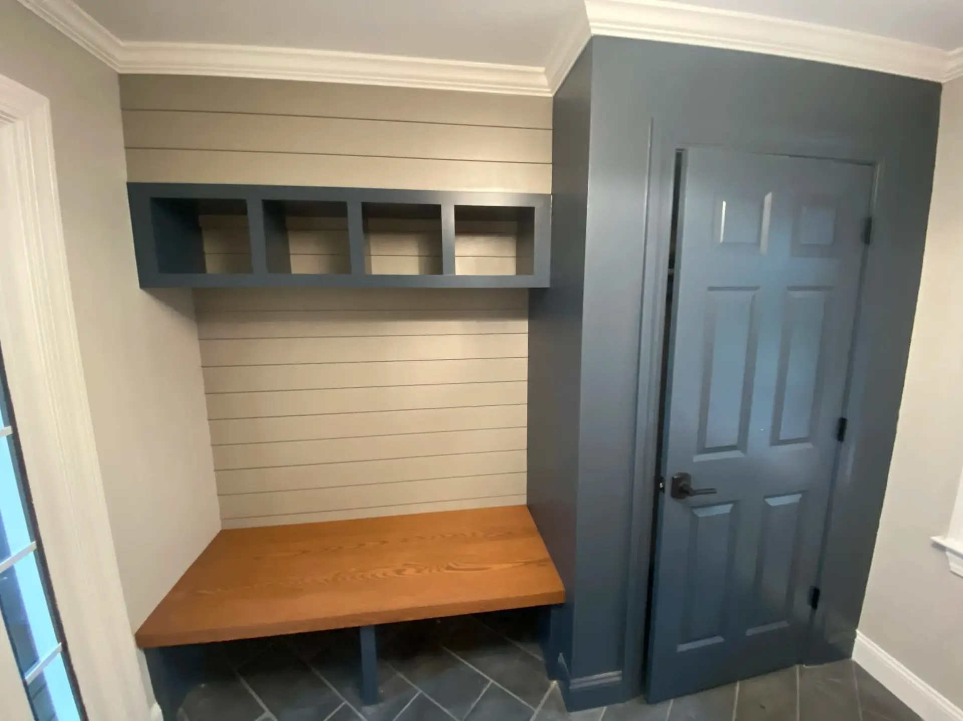 Custom mudroom featuring shiplap wall, built-in cubbies, and wooden bench in a newly constructed home in Wakefield, MA.