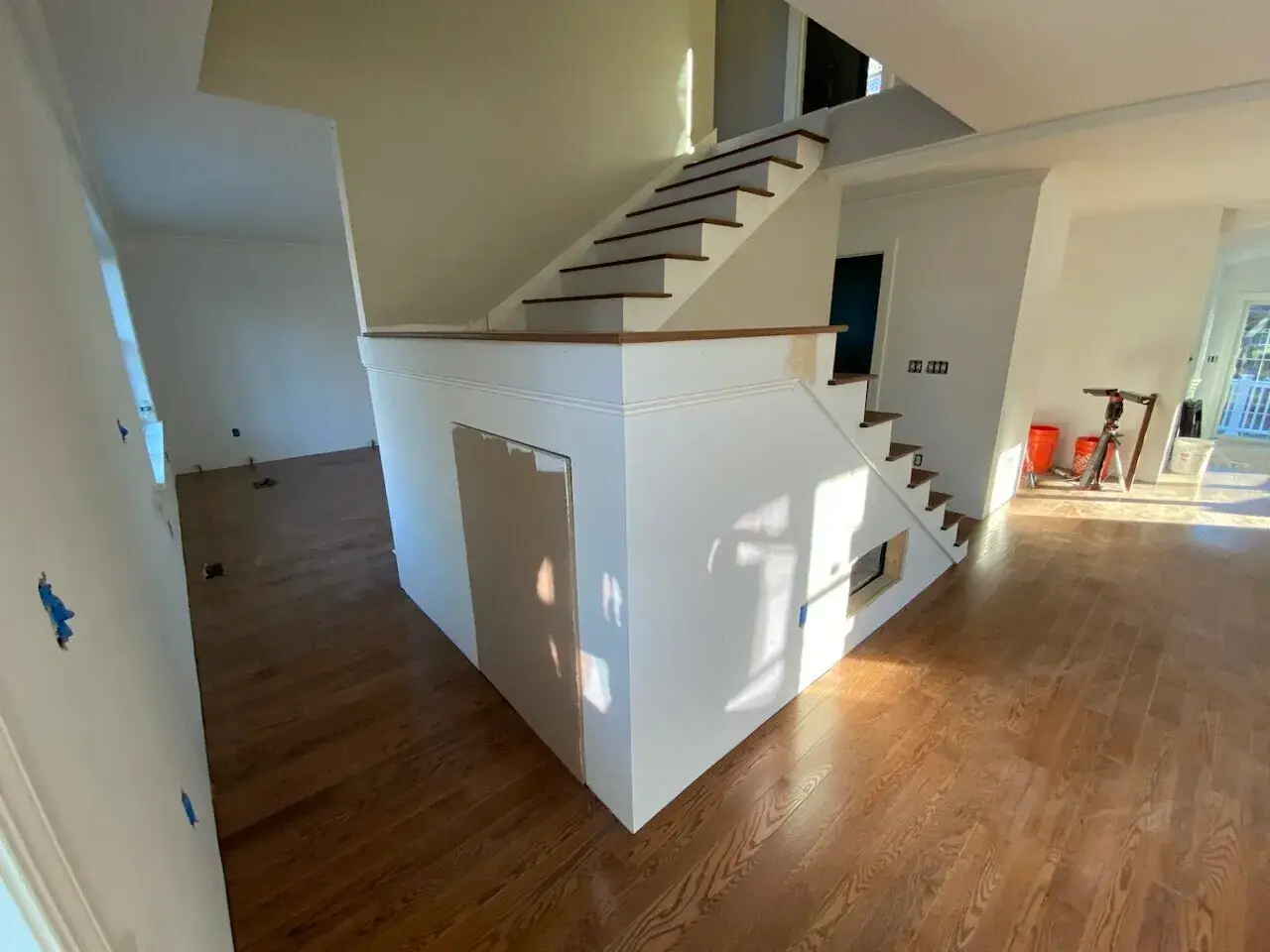 Custom hardwood staircase with oak railing in a newly constructed home interior, featuring natural light and hardwood flooring in Wakefield, MA.