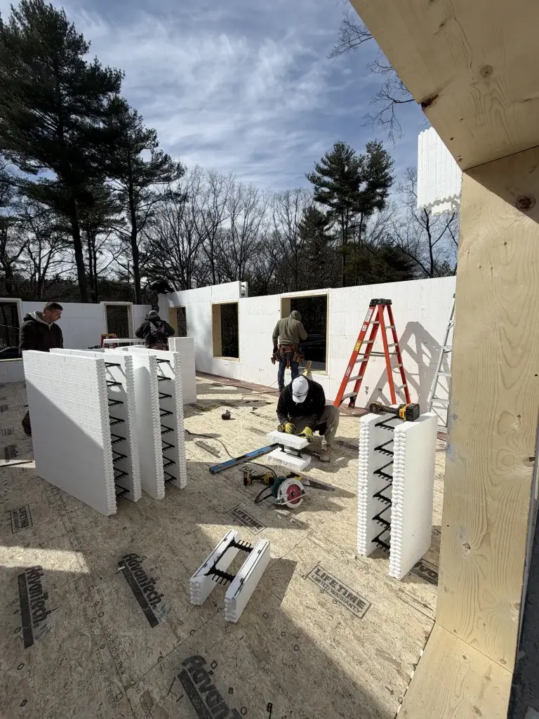 Construction manager reviewing blueprints with homeowner at a construction site