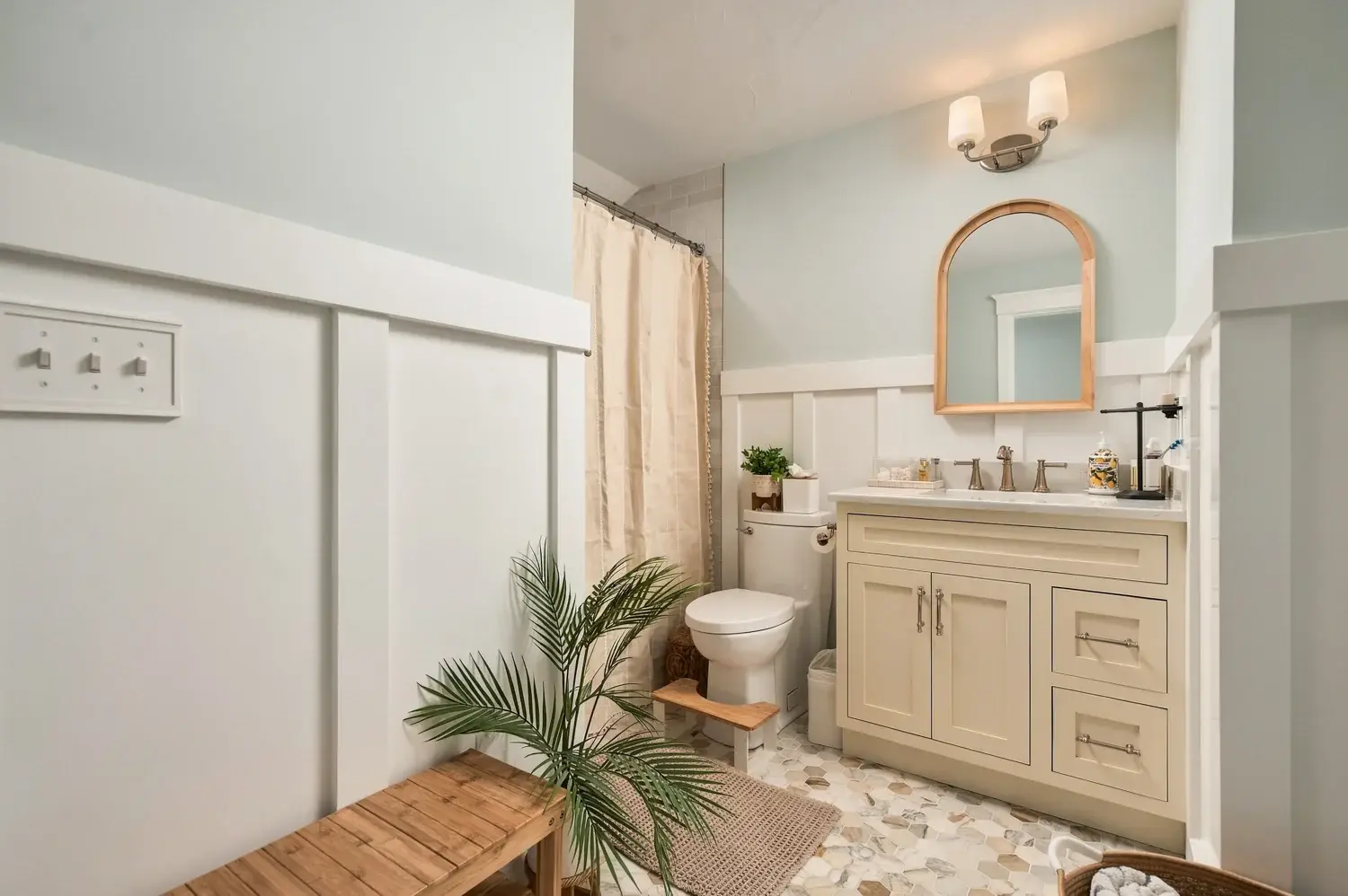 Guest bathroom with blue walls, white paneling, and inset vanity