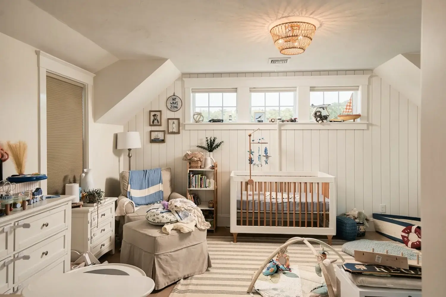 Nursery with white shiplap, windows, and wood flooring