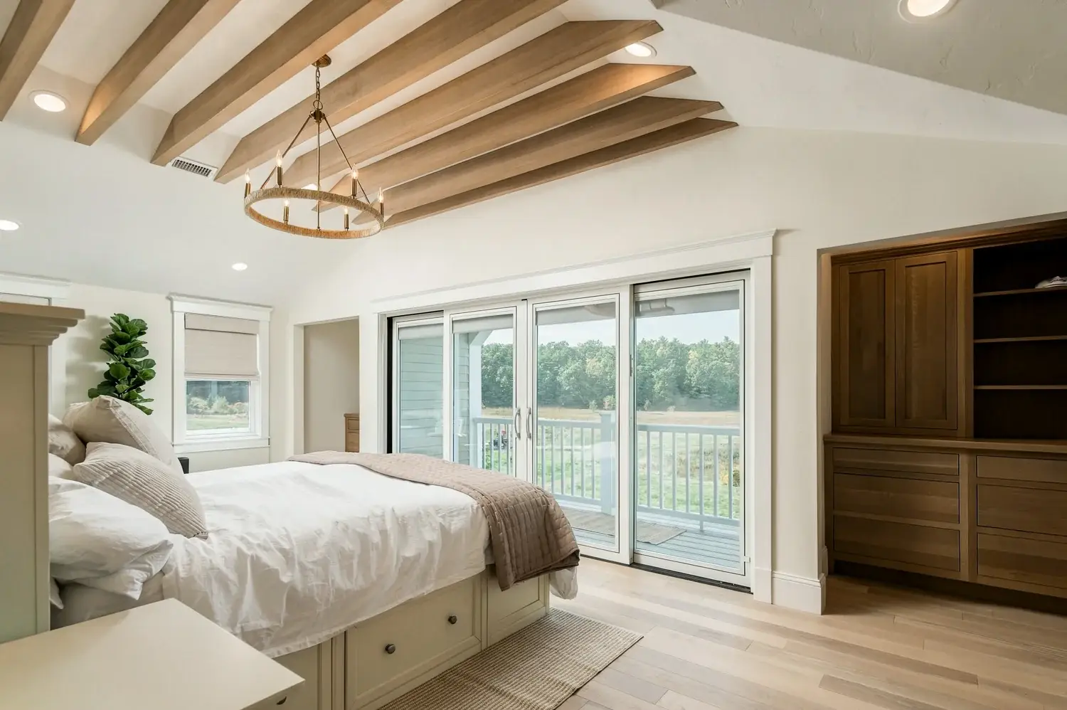 The finished primary bedroom opens onto the balcony through sliding doors